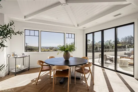 a view of a dining room with furniture large windows and wooden floor