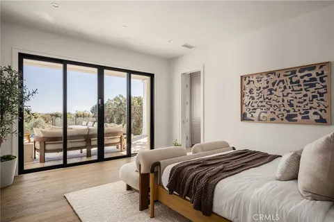 a bedroom with a large bed and a large window with outer view