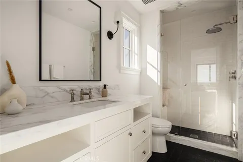 a bathroom with a sink toilet double vanity and shower