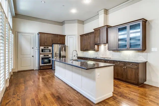 a kitchen with stainless steel appliances granite countertop a refrigerator and a stove top oven