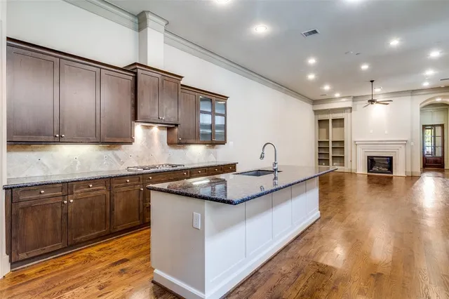 a kitchen with granite countertop a sink and cabinets