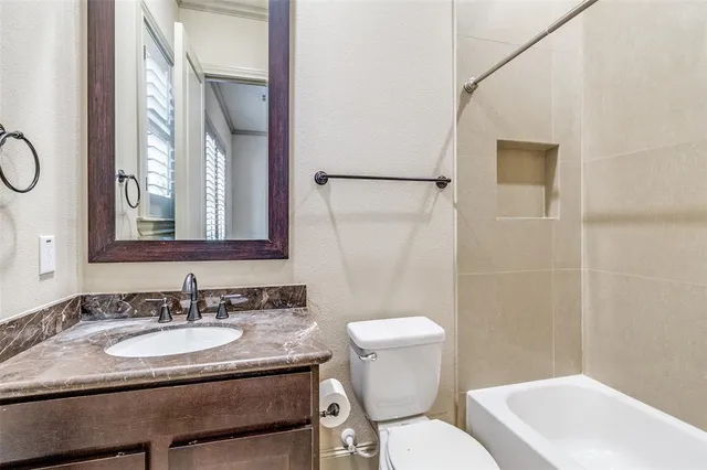 a bathroom with a granite countertop sink toilet a mirror and shower