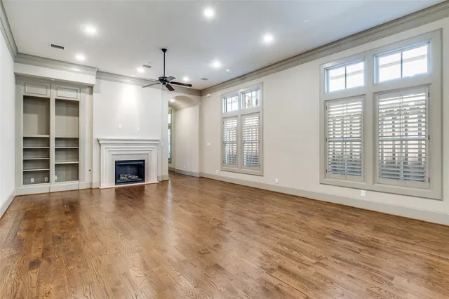 a view of empty room with wooden floor and fireplace