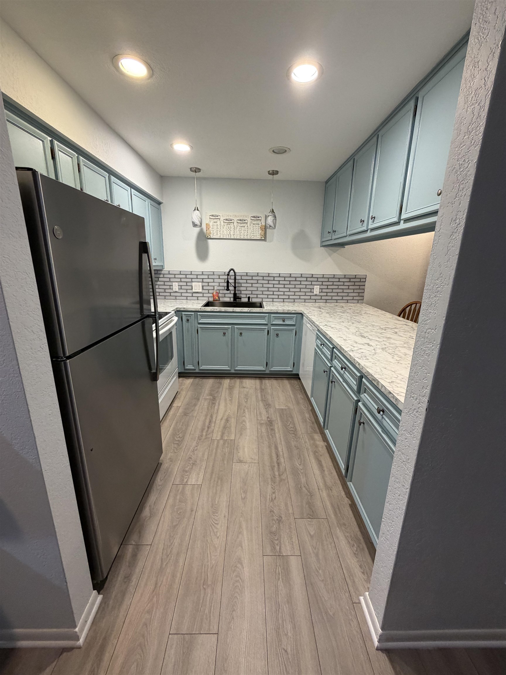 307 Crestview Horseshoe Bay, TX 78657 - Photo 8 of 24 a kitchen with kitchen island wooden floors appliances and cabinets
