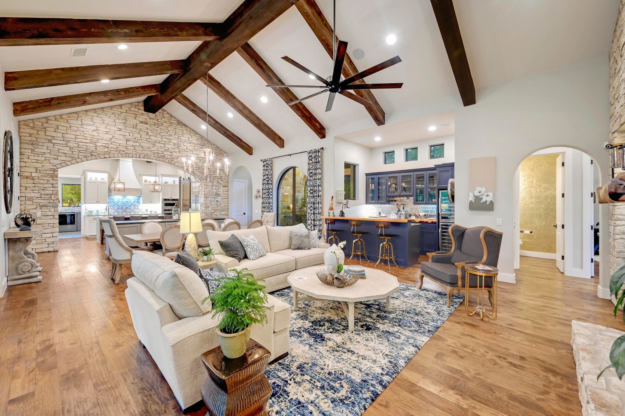 401 Trail Ridge Road Wimberley, TX 78676 - Photo 5 of 34 Living room featuring arched walkways, high vaulted ceiling, ceiling fan, beam ceiling, and wood finished floors