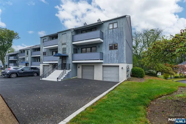 a front view of a house with a garden and parking space