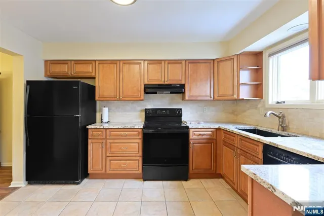 a kitchen with stainless steel appliances granite countertop a stove sink and cabinets