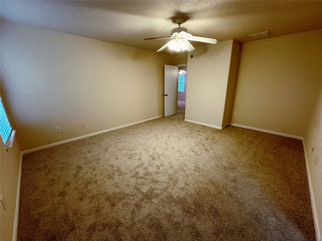 an empty room with a chandelier fan and a chandelier fan