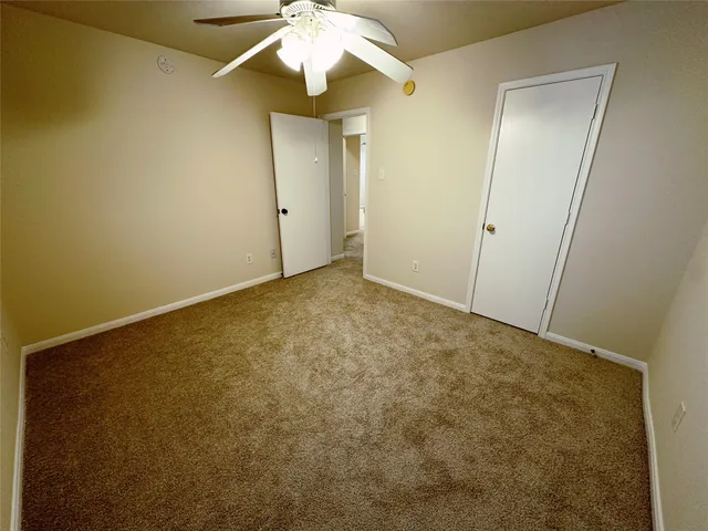 an empty room with a chandelier fan and a chandelier fan