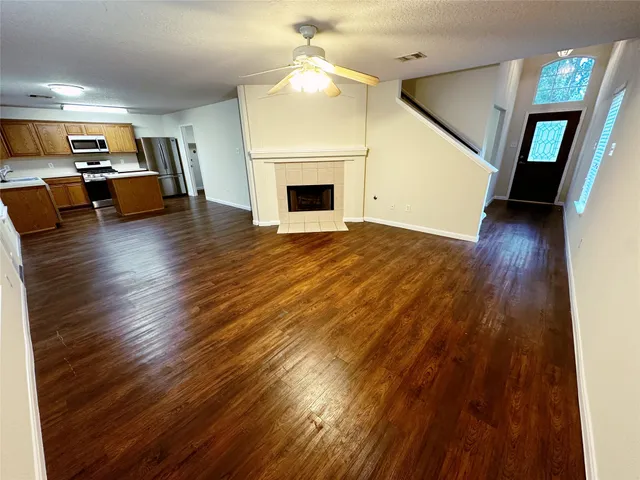 a view of a livingroom with furniture wooden floor staircase and a kitchen