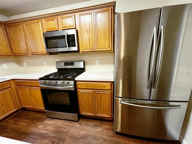 a kitchen with stainless steel appliances granite countertop a refrigerator stove and microwave