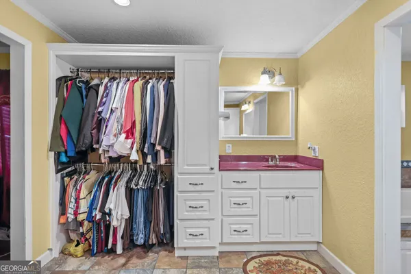 a view of walk in closet with clothes