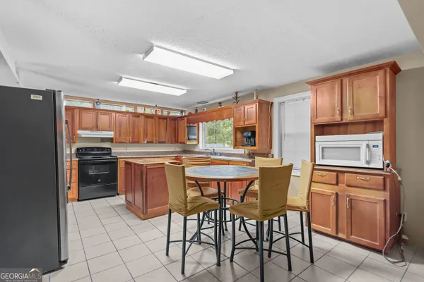 a kitchen with a table chairs refrigerator and cabinets