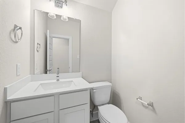 a bathroom with a sink mirror vanity and toilet