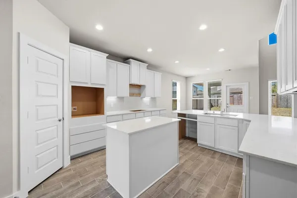 a kitchen with white cabinets appliances and sink