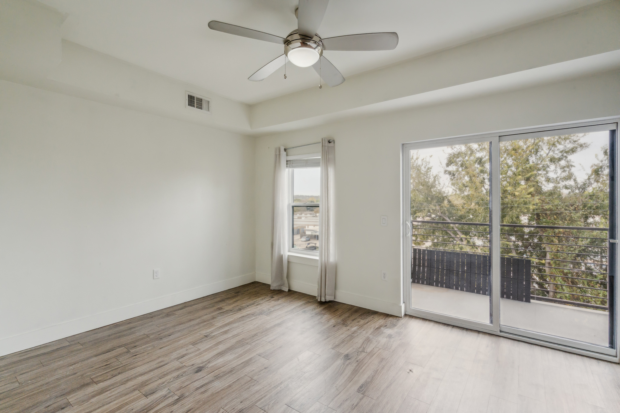 6444 Burnet Road, Unit 305 Austin, TX 78757 - Photo 2 of 13 a view of empty room with wooden floor and fan