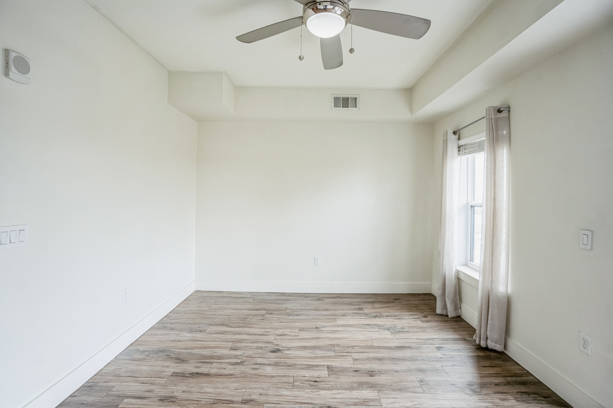 6444 Burnet Road, Unit 305 Austin, TX 78757 - Photo 3 of 13 an empty room with wooden floor and windows