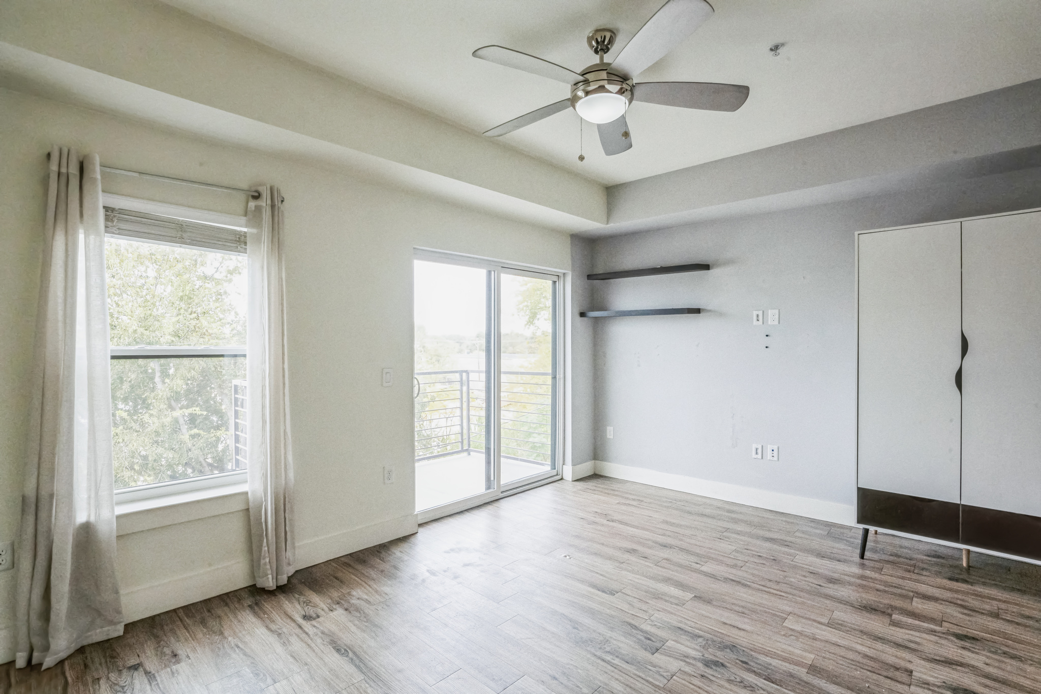 6444 Burnet Road, Unit 305 Austin, TX 78757 - Photo 5 of 13 a view of an empty room with a window and wooden floor