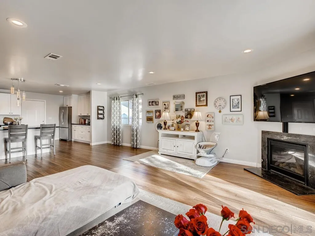 9559 Tuthill Way Santee, CA 92071 - Photo 1 of 27 a living room with furniture and a fireplace with kitchen view