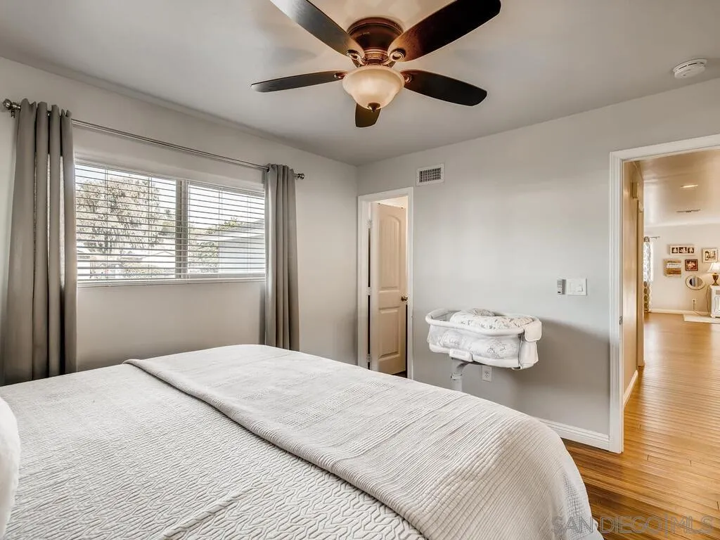 9559 Tuthill Way Santee, CA 92071 - Photo 16 of 27 a bedroom with a bed and a chandelier