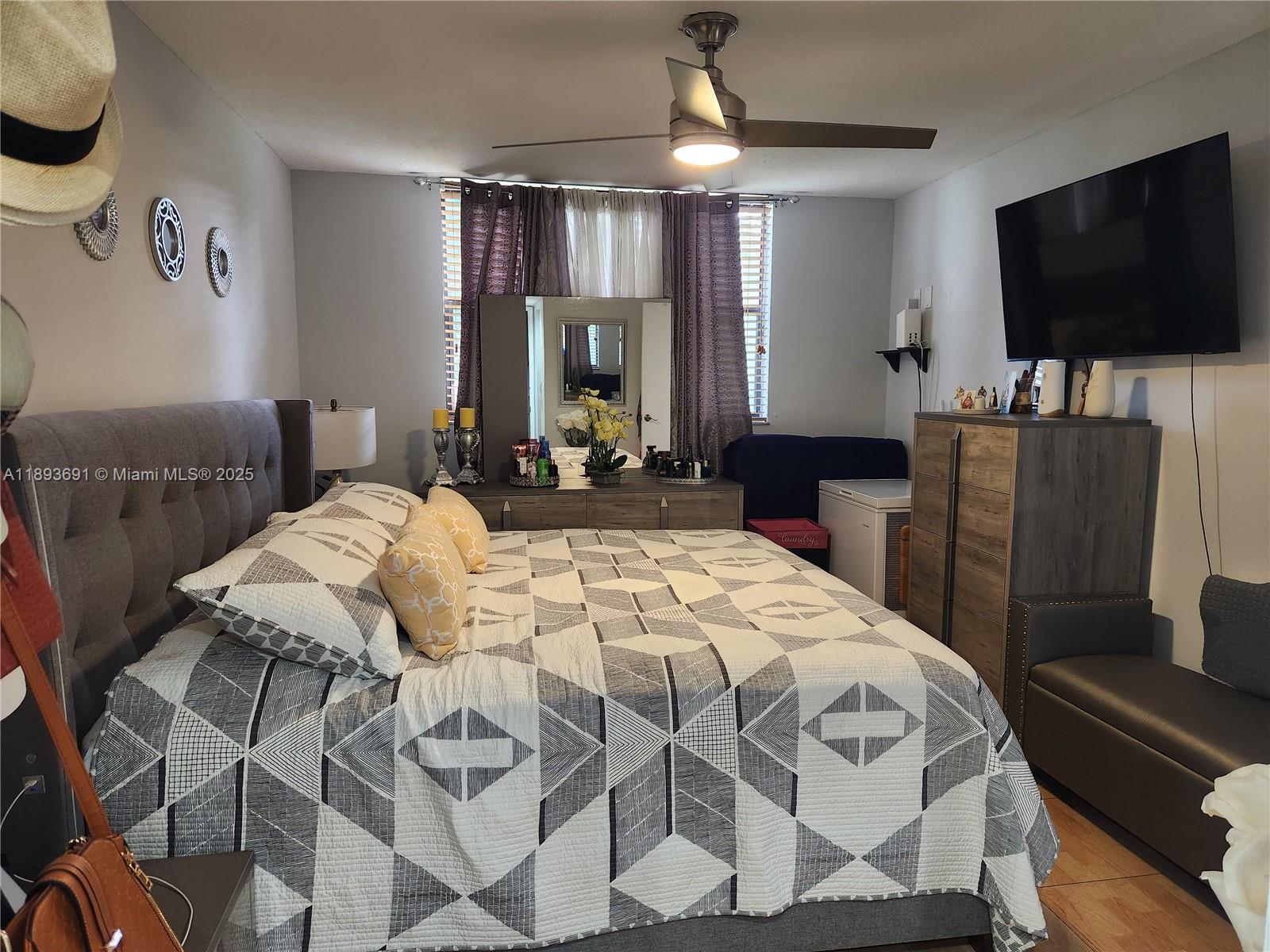 8000 Southwest 149th Avenue, Unit A107 Miami, FL 33193 - Photo 6 of 15 a bedroom with a bed and a flat tv screen on the dresser