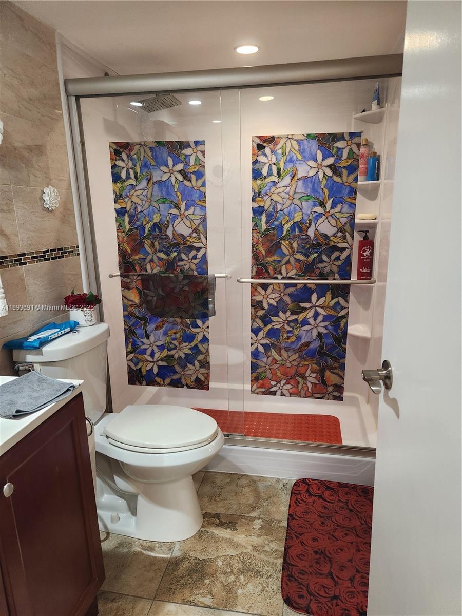 8000 Southwest 149th Avenue, Unit A107 Miami, FL 33193 - Photo 7 of 15 a bathroom with a toilet and a shower curtain