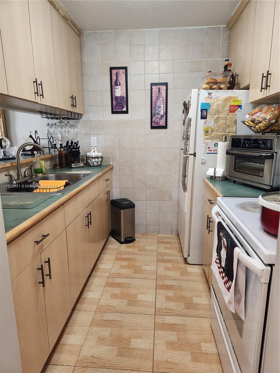 8000 Southwest 149th Avenue, Unit A107 Miami, FL 33193 - Photo 8 of 15 a kitchen with granite countertop a sink stove and cabinets