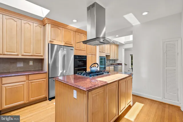 a kitchen with stainless steel appliances granite countertop a refrigerator a sink and a stove