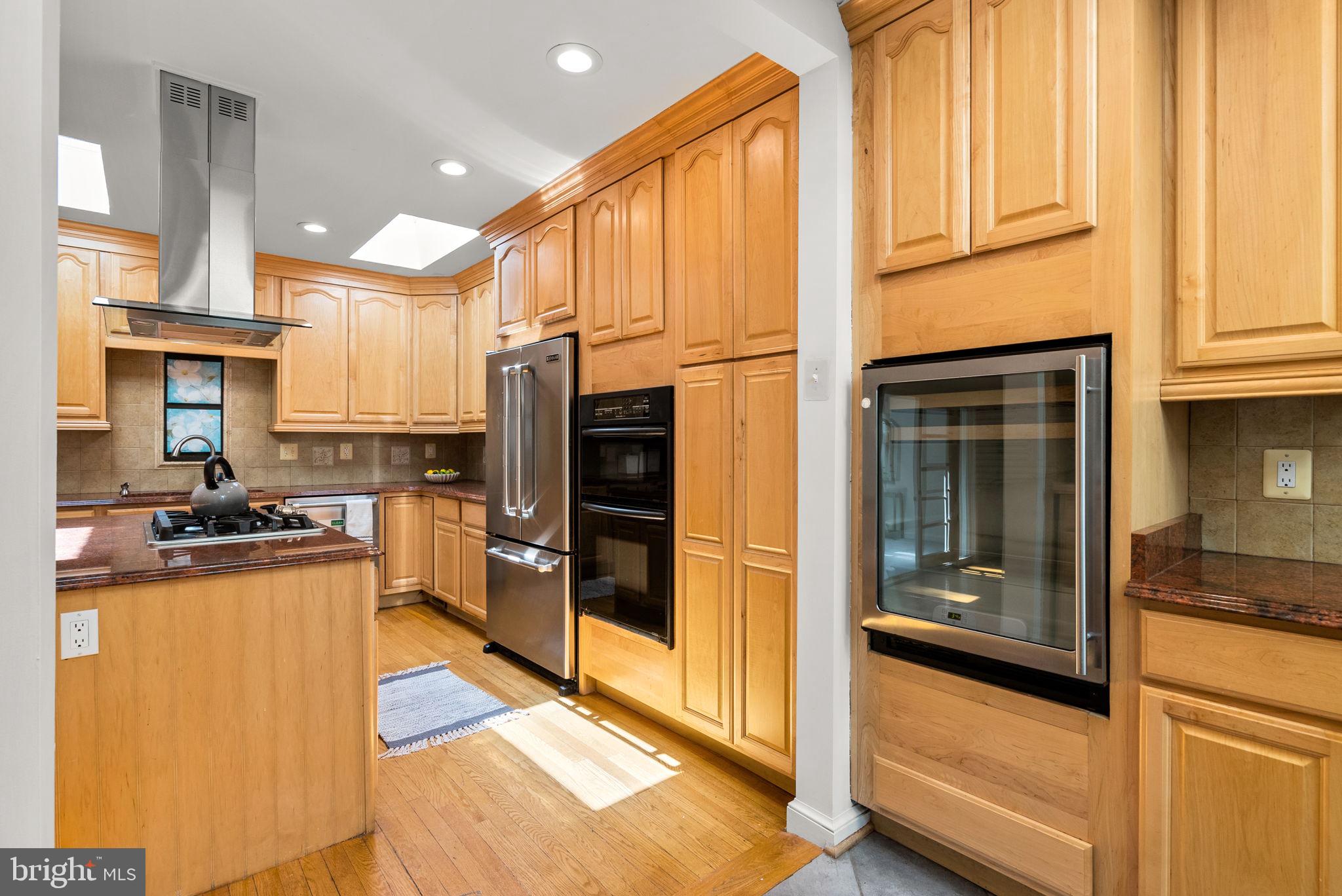 2816 Linden Lane Silver Spring, MD 20910 - Photo 14 of 62 a kitchen with stainless steel appliances granite countertop a refrigerator a stove and a sink with wooden floor