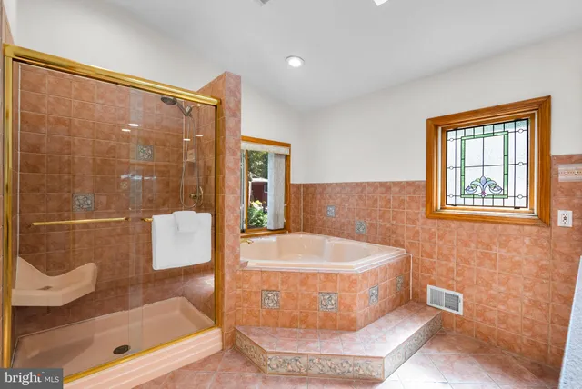 a bath tub sitting next to a blue sink and a shower