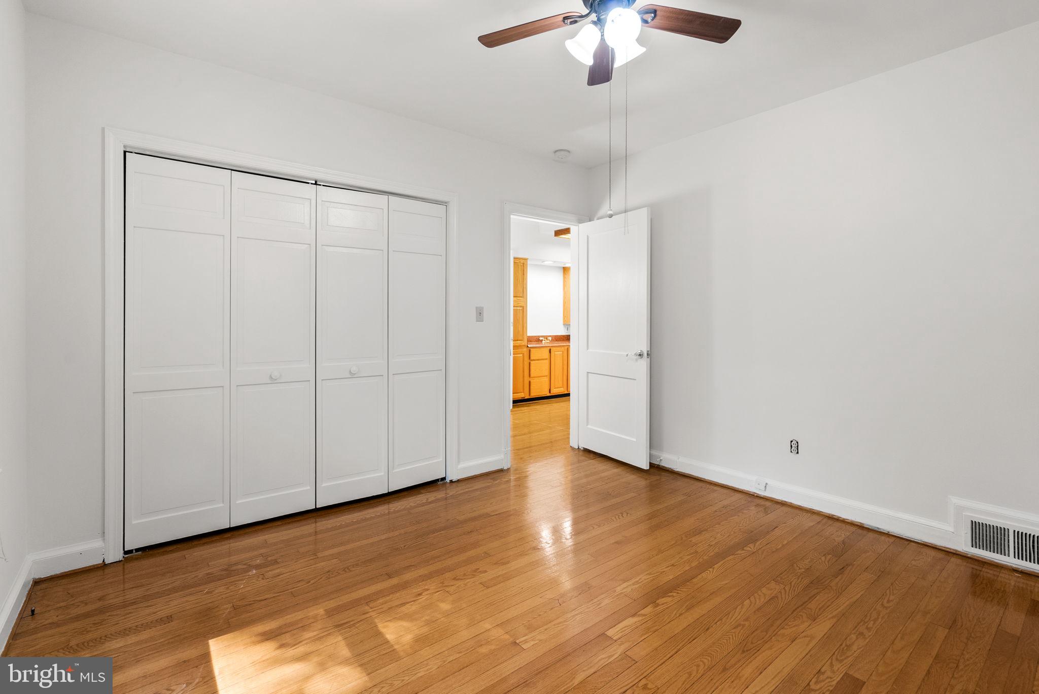 2816 Linden Lane Silver Spring, MD 20910 - Photo 32 of 62 an empty room with wooden floor chandelier fan and windows