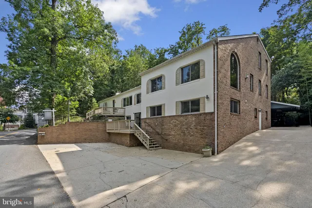 a view of a white house with a yard and large tree