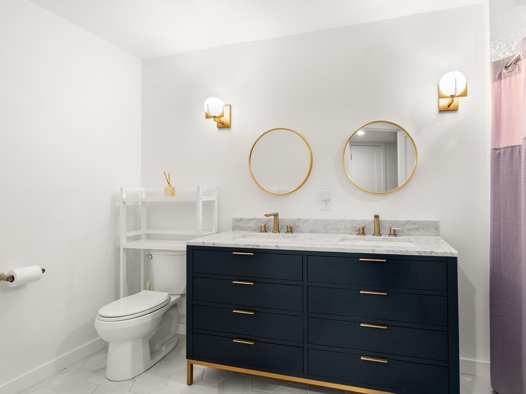 811 Hammond Street Chestnut Hill, MA 02467 - Photo 21 of 30 a bathroom with a toilet a double vanity sink and a mirror