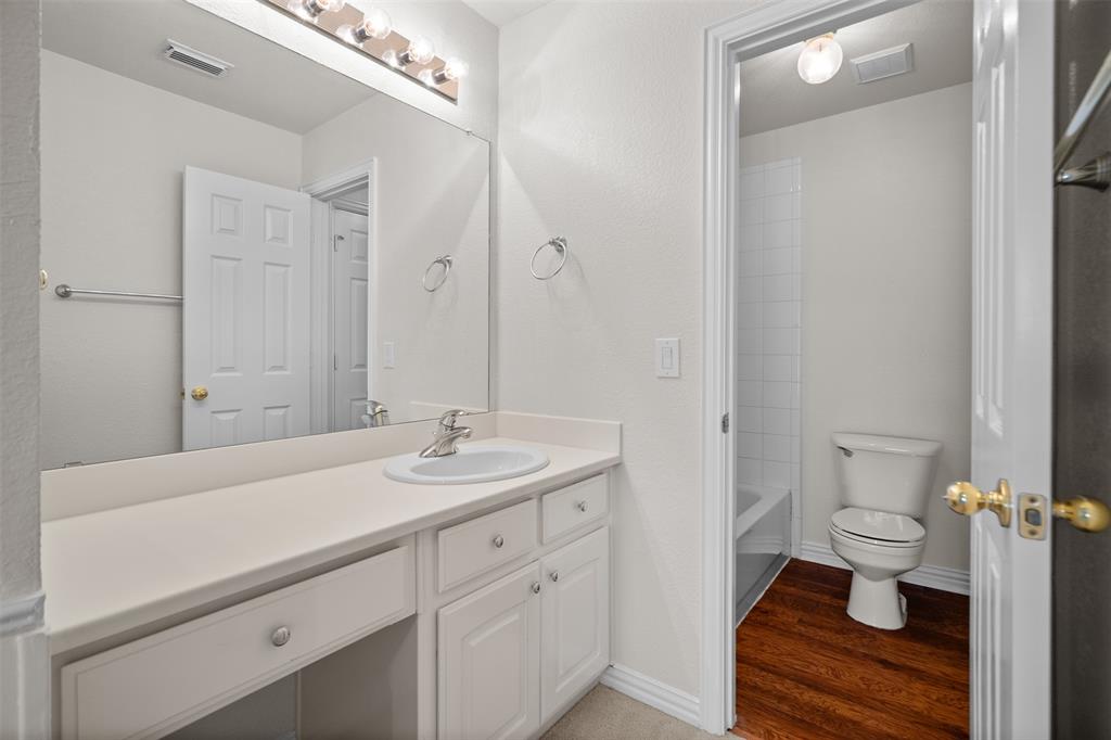 4405 Ridgecove Drive Rowlett, TX 75088 - Photo 22 of 37 Vanity with an integrated sink, built-in cabinetry, and a full-width mirror with overhead lighting