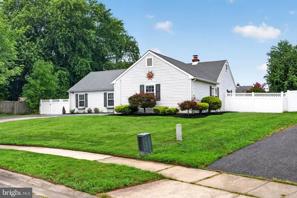 a front view of a house with a yard and trees