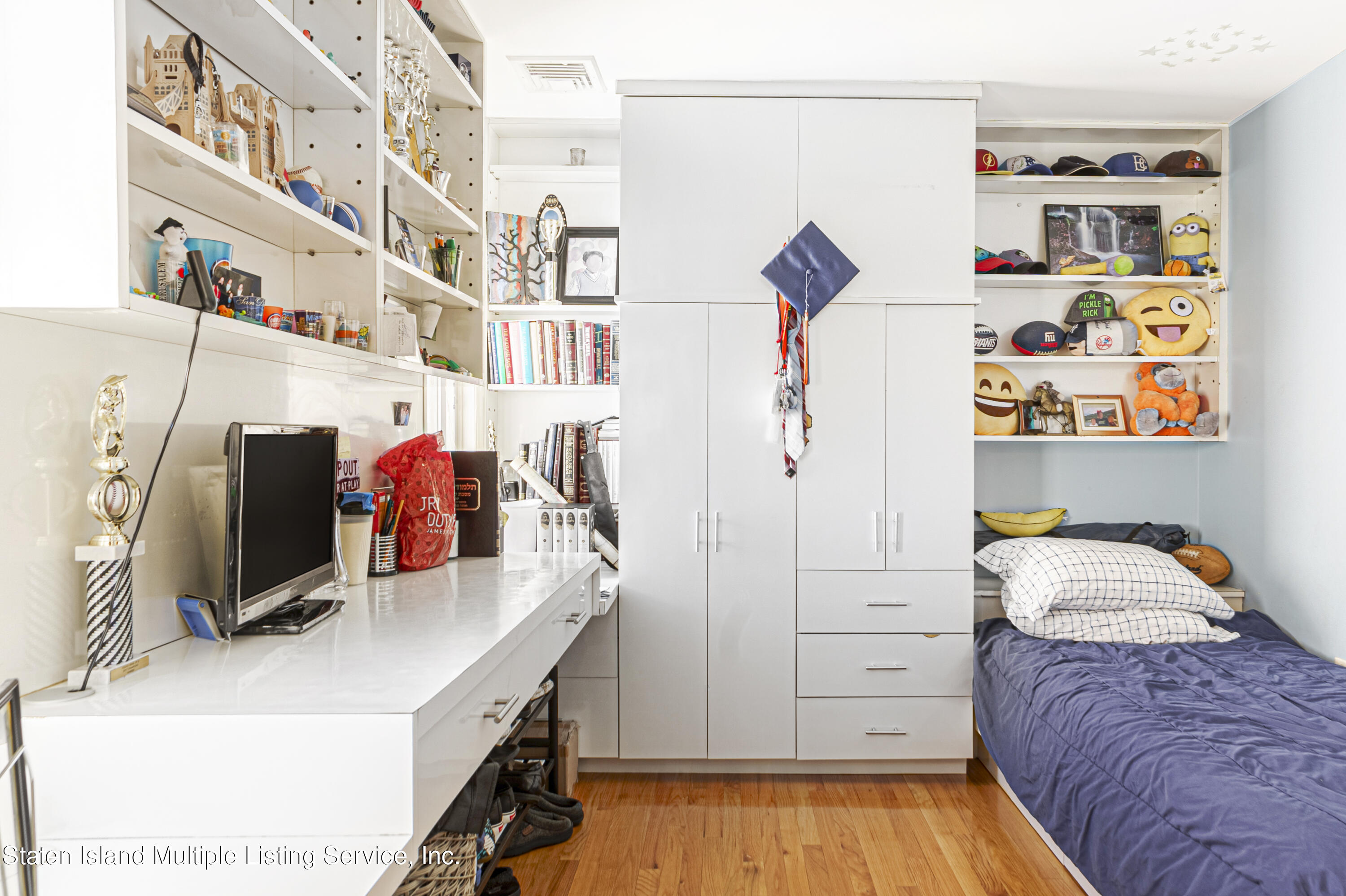 19 Bascom Place Staten Island, NY 10314 - Photo 31 of 54 a bedroom with a bed and a book shelf