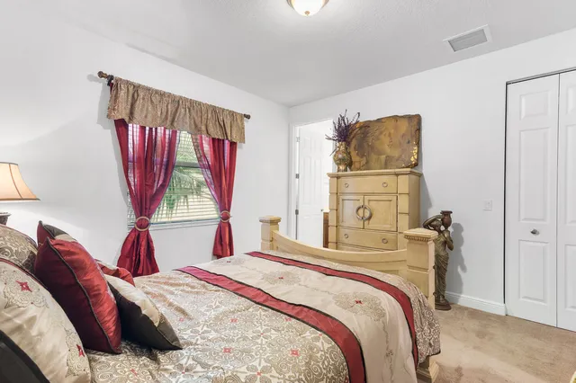 a bedroom with a bed and a dresser next to a window