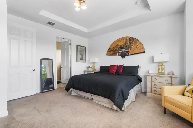 a bedroom with a bed and a painting on the wall