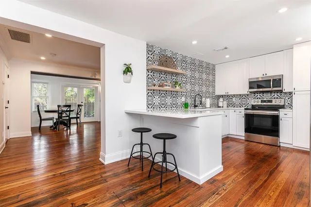 a open kitchen with a table chairs refrigerator and cabinets