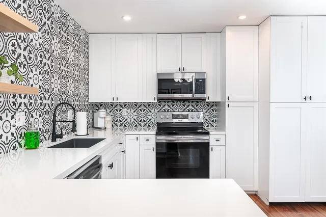 a kitchen with stainless steel appliances granite countertop a stove a sink and a refrigerator