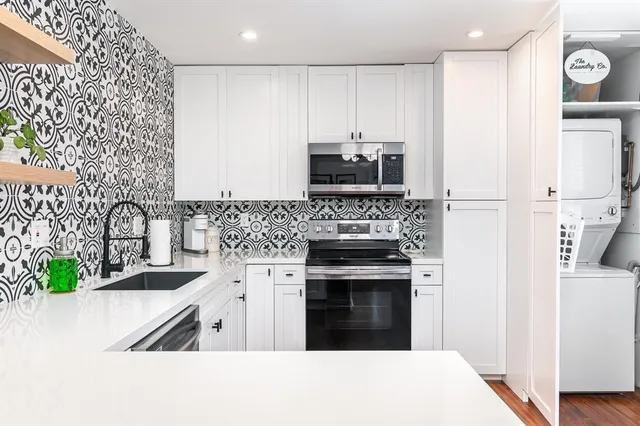 a kitchen with stainless steel appliances granite countertop a stove a sink and a refrigerator