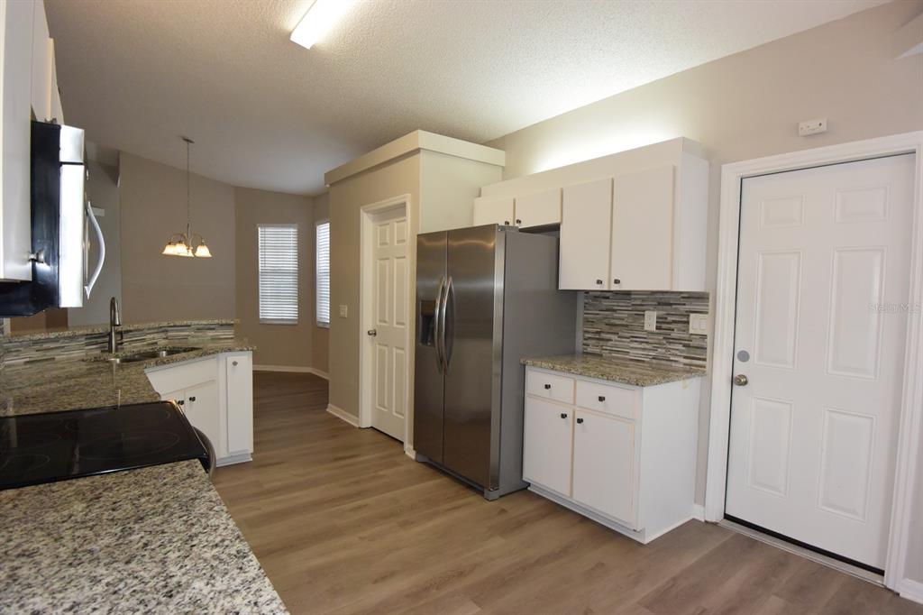 2339 Renton Lane Spring Hill, FL 34609 - Photo 11 of 35 a kitchen with a refrigerator and a sink
