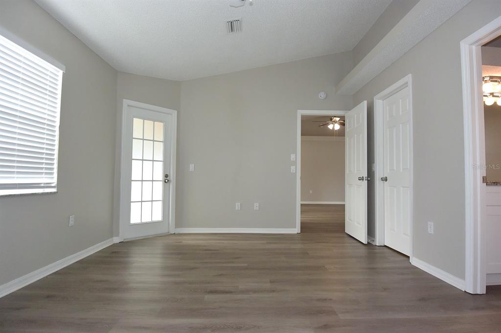 2339 Renton Lane Spring Hill, FL 34609 - Photo 16 of 35 an empty room with wooden floor and windows