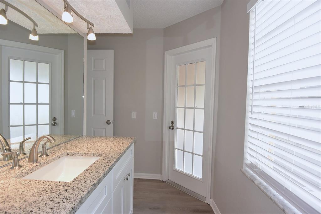 2339 Renton Lane Spring Hill, FL 34609 - Photo 26 of 35 a bathroom with a granite countertop sink and a mirror