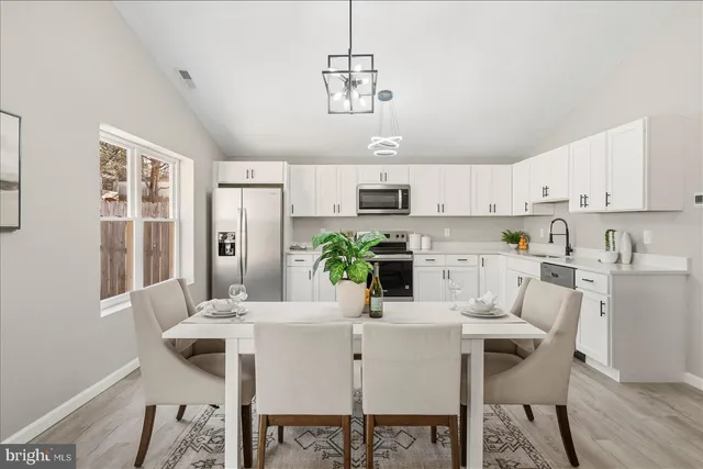 a kitchen with kitchen island granite countertop a sink a center island and appliances