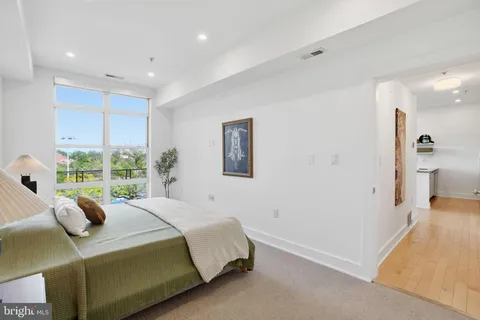 a bedroom with a bed and a large window