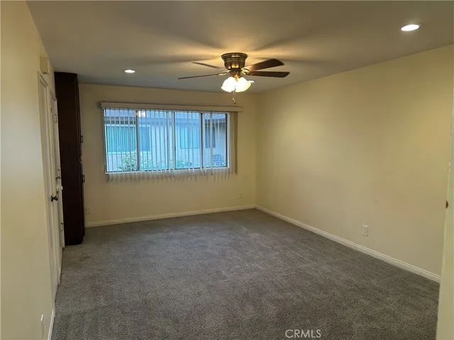 a view of a livingroom with a ceiling fan and window
