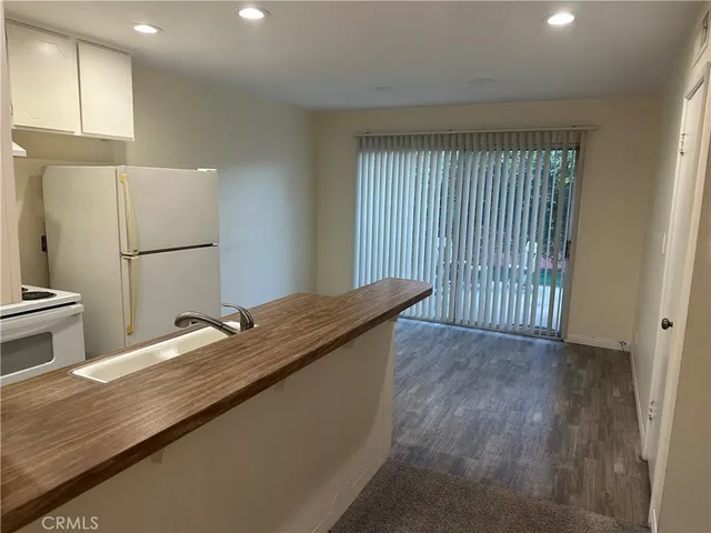 a kitchen with granite countertop a sink a refrigerator and a stove