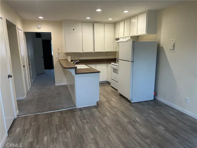 a kitchen with stainless steel appliances granite countertop a refrigerator a sink and a stove