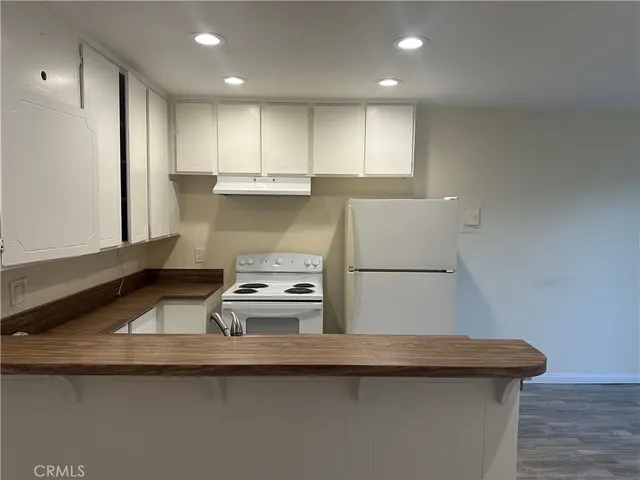 a kitchen with a sink a stove and wooden cabinets